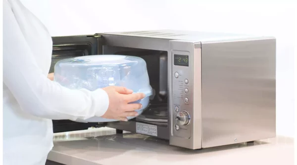 Round Sealable Microwave Steriliser in White being placed into a Silver Microwave